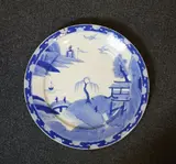 A Chinese porcelain plate, 19th century, painted in blue and white in the willow bridge pattern