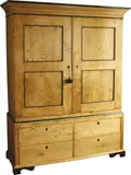 A Biedermeier linen press, In Karelian birch with upper section of two panelled doors enclosing shelves beneath an architectural cornice