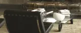Industrial designer, glass coffee table, on wheels in center of installation shot