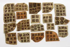 19 earthenware tablets by Len Castle and Theo Schoon, 19 umber pigmented earthenware tablets made by Castle, impressed with Schoon's stamps, sold May 2007
