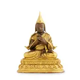 A finely cast gilt-bronze figure of Tsongkhapa (1357-1419), shown in the gesture of teaching, with lotus stalks supporting the Perfection of Wisdom and the sword of wisdom. He wears the pointed scholar's hat with long lappets, characteristic of the Gelug tradition he founded. The figure is crisply detailed and well balanced, with the sealed base preserving its original consecration. by Qianlong Period A Sino-Tibetan Gilt-Bronze Seated Tsongkhapa, sculpture, sold Nov 2025