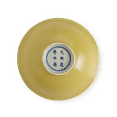 Wanli Six-Character Mark In Underglaze Blue Within A Double Circle And Of The Period A Fine Chinese Yellow-Enamelled Bowl, The bowl is thinly potted with rounded sides rising to a slightly flared rim, supported on a short foot, enamelled inside and out with a rich yellow enamel of deep egg-yolk tone. The base is covered with a clear glaze.