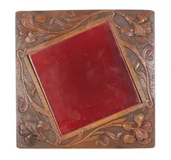Attibuted To Mildred Creed A Carved Blackwood Art Nouveau Teapot Stand, Inset with a crimson ceramic tile within a design of stylised iris, relief carved monogram MMC to underside.