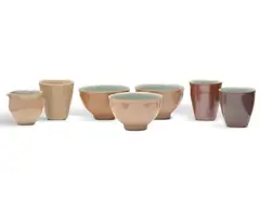 Two Beakers (Bronze), Cup (Cream), Jug and Three Bowls (Blue and Cream) c1990 by Gwyn Hanssen-Pigott, c1990, woodfired porcelain (7), offered Jun 2025