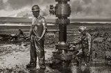 Sebastião Salgado, Workers install a new wellhead to enable the injection of a chemical mud to "kill the old well." Greater Burhan, Kuwait