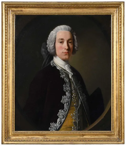 Allan Ramsay, Sir John Peachey (1720-1765), 3rd Baronet, West Dean, Sussex, wearing a silver brocaded plum velvet coat and yellow waistcoat, and holding a tricorn hat under his proper left arm, presented half-length in a feigned oval, oil on canvas
