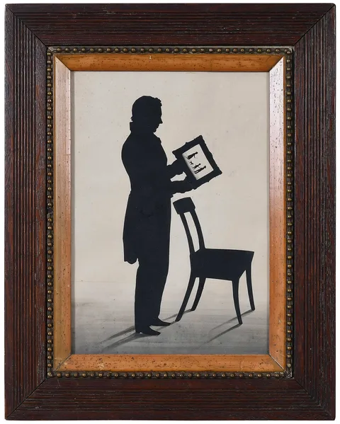 Auguste Edouart, Self Portrait, Holding a Family Silhouette, ink cutout on cream paper with ink accents and wash
