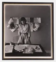 Arnold Newman, Dame Mary Quant, 1978, a bromide print photograph of Mary Quant standing in front of her work desk