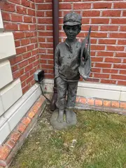 Marion Smith, Untitled, a bronzed resin figure of a boy holding a pond yacht