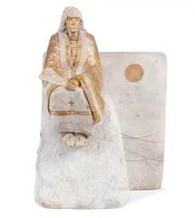 Oreland C. Joe, A Native American seated on a rocky outcrop, carved stone