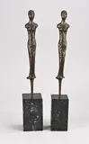 2x Beeld, Staande dames, Twee moderne bronzen damesfiguren op zwart marmeren sokkels
