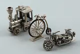 3 Zilv. miniaturen, vervoer, Drie zilveren miniaturen 925/000: locomotief, motorfiets en velociipede, samen ca