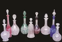 Glass Decanters, Group of Nine, A group comprising four coloured glass decanters, red, rose, green and blue with varying shapes and etched and cut designs, also five clear glass decanters, of varying shapes and cut designs.