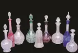 Glass Decanters, Group of Nine, A group comprising four coloured glass decanters, red, rose, green and blue with varying shapes and etched and cut designs, also five clear glass decanters, of varying shapes and cut designs.