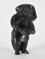 Untitled - Woman with Pack by Qaunaq Mikkigak, black stone carving, sold Mar 2026