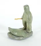 Untitled - Happy Hunter with Seal by Sarah Kimagyogina Novoligak, 1973, grey stone carving, sold Mar 2021
