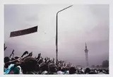 Guy Tillim, A Statue Of Patrice Lumumba Erected By Laurent Kabila, And An Unfinished Tower Built During The Mobutu Years, Look Down On Jean- Pierre Bemba Supporters As They Make Their Way To A Rally, Kinshasa, Ju, 2006, archival pigment ink on 300g cotton paper
