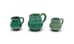 Three jugs, in sizes by Linn Ware, green- and sage-glazed earthenware, sold May 2025