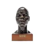 Bust of The Accused by Frederik Johannes (Frikkie) Kruger, bronze with brown patina, on a wooden base, sold Jul 2024