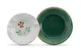 Two Dishes, one hand painted with a flower and with flowerhead prunts, the other with a green glaze, two by Hylton Nel, manganese glazed earthenware, sold Apr 2022