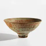 Footed bowl by Lucie Rie, circa 1978, Stoneware with manganese speckle, pitted and flowing green and brown glaze, sold Jun 2025