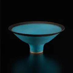 Footed bowl by Lucie Rie, circa 1976, Stoneware, matte blue glaze with golden manganese band, sold Dec 2024