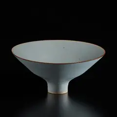 Footed bowl by Lucie Rie, circa 1966, Porcelain with cobalt and manganese speckle, light blue glaze with manganese rim, sold Dec 2024
