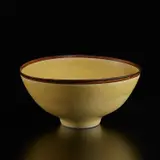Footed bowl by Lucie Rie, circa 1968, Porcelain, matte yellow glaze with manganese rim, sold Dec 2024
