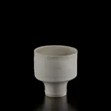 Small straight-sided bowl by Lucie Rie, 1974, Porcelain, matte white glaze with pale blue inlaid bands repeated inside and out, sold Dec 2024