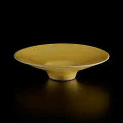 Footed open bowl by Lucie Rie, circa 1968, Stoneware, shiny yellow glaze, sold Dec 2024