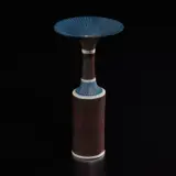 Cylindrical vase with flaring lip by Lucie Rie, 1976, Porcelain, dark brown manganese glaze with blue shoulder and rim sgraffito, and inlaid blue lines, sold Dec 2024