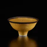 Footed bowl by Lucie Rie, circa 1978, Grogged porcelain, shiny yellow glaze with golden manganese rim, sold Dec 2024