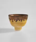 Footed bowl by Lucie Rie, circa 1978, Porcelain, yellow glaze with golden manganese lip, sold Feb 2021