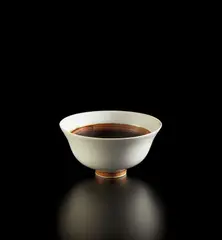 Footed bowl by Lucie Rie, circa 1952, Porcelain, white and manganese glaze, sold Dec 2020