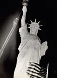 Weegee, Man climbs 85-foot ladder to secure torch on the plastic Statue of Liberty erected at Times Square for the Sixth War Loan Drive, New York, November 30, 1944, Gelatin silver print