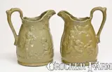 Extremely Rare Pair of JOHN BELL / WAYNESBORO Redware Pitchers with Molded Cherub Design by John Bell, circa 1850-1880, Redware, sold Apr 2022