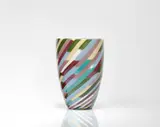 Venini & C. Murano, A 'Klee' vase
Venini & C., Murano, designed by Laura Diaz de Santillana, produced in 1981., Clear glass with white underlay and polychrome diagonal stripes. Inscribed on the base "venini Laura 81", two manufacturer's labels. H