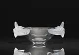 Lalique Verrerie, A Coupe Loriol
Lalique, Wingen-sur-Moder, 1990s / early 2000s., Clear mould-pressed glass, patinated. Etched signature Lalique ® France, labelled LALIQUE PARIS. H 18, upper W