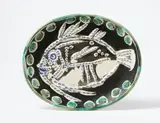 Poisson fond noir by Pablo Picasso, 1952, Oval ceramic plate. White mass with relief decor, grey engobe and partialy glazed in white, green and blue; ceramic, Mad, sold Jun 2023