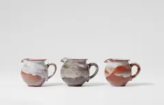 Otto Lindig, Three ceramic milk jugs by Otto Lindig (1895 - 1966), Red earthenware, white gradient glaze, salt glaze. Incised with conjoined OL monogram. H 6.9, 6.8 and