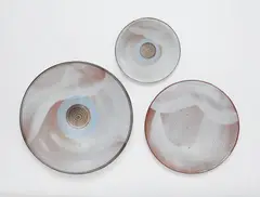 Otto Lindig, Three shallow dishes by Otto Lindig (1895 - 1966), Red earthenware with white glaze, two dishes with pale blue and brown circular decor. Incised with conjoined OL monogram. D 18.9, 27.4 and