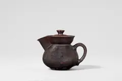 Otto Lindig, A small ceramic ewer with a lid by Otto Lindig (1895 - 1966), Red earthenware with dark brown to matte black gradient glaze, interior white