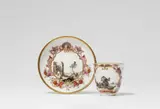 Meissen Royal Porcelain Manufactory, A Meissen porcelain cup and saucer with landscapes in cartouches