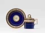Meissen Royal Porcelain Manufactory, A Meissen porcelain lidded cup and saucer with arabesque decor