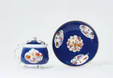 Johann Ehrenfried Stadler, A Meissen porcelain cream pot and stand with midnight blue ground