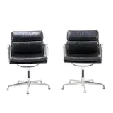 PAIR OF 'EA433' SOFT PAD SIDE CHAIRS FOR HERMAN MILLER by Charles and Ray Eames, Black padded leather over an aluminium and metal frame on universal five star base. Herman Miller mark embossed to frame, sold Nov 2025
