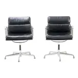 PAIR OF 'EA433' SOFT PAD SIDE CHAIRS FOR HERMAN MILLER by Charles and Ray Eames, Black padded leather over an aluminium and metal frame on universal five star base. Herman Miller mark embossed to frame, sold Nov 2025