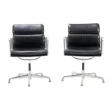 PAIR OF 'EA433' SOFT PAD SIDE CHAIRS FOR HERMAN MILLER by Charles and Ray Eames, Black padded leather over an aluminium and metal frame on universal five star base. Herman Miller mark embossed to frame, sold Nov 2025