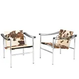 / CHARLOTTE PERRIAND PAIR OF 'LC1' ARMCHAIRS FOR CASSINA by Le Corbusier and Pierre Jeanneret, Cowhide upholstered sling seat and backrest on chromed tubular steel frame with black leather armrests. Manufacturer det, sold Jul 2025