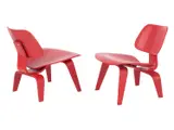 Charles and Ray Eames, A PAIR OF LCW CHAIRS FOR HERMAN MILLER, Red stained moulded plywood with rubber shock mounts. Stamps and stickers present to undersides